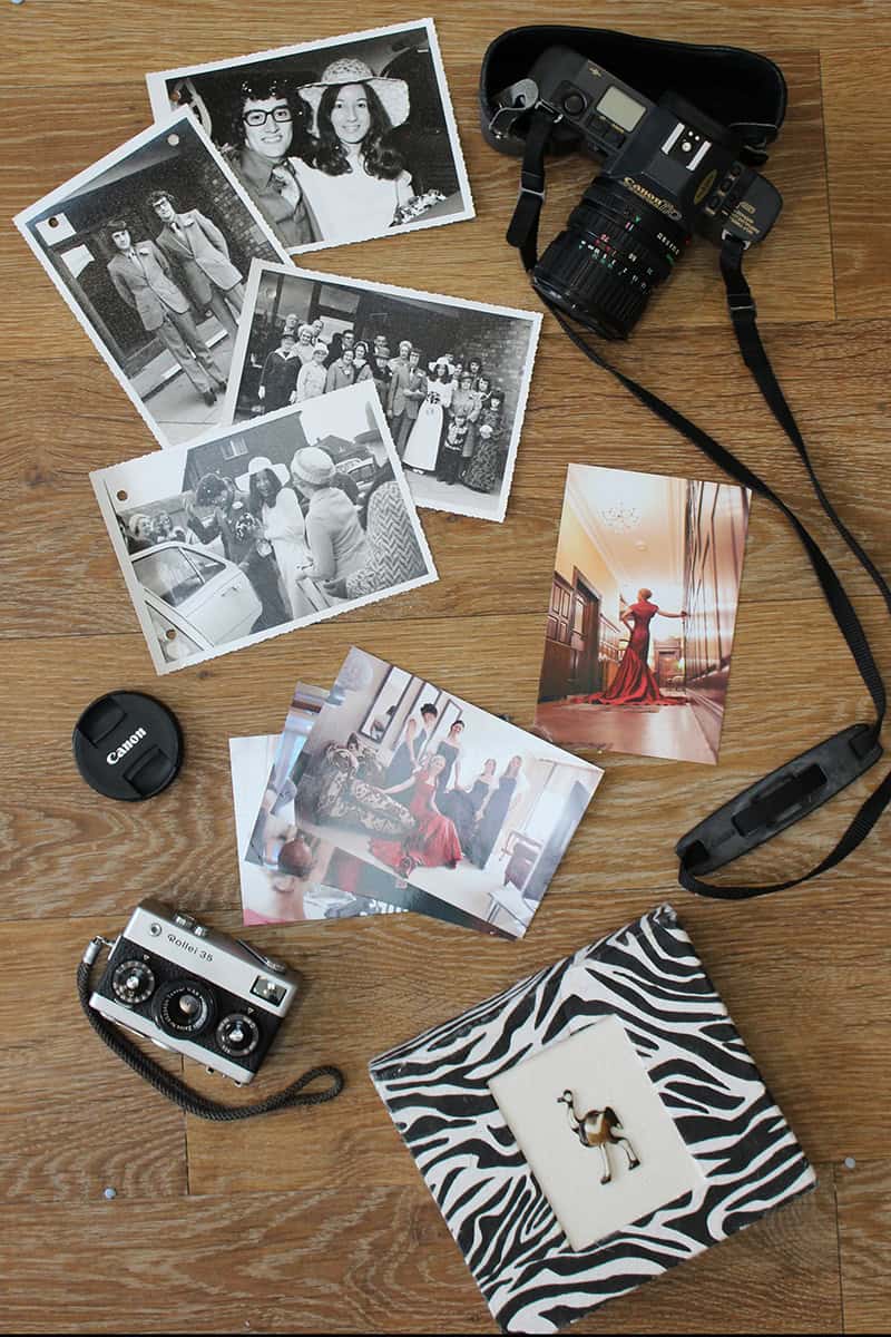 Professional photography gear, photos, and props displayed on a wooden surface.